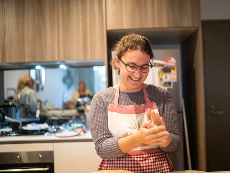 Woman smiling as she cooks food at a cooking class